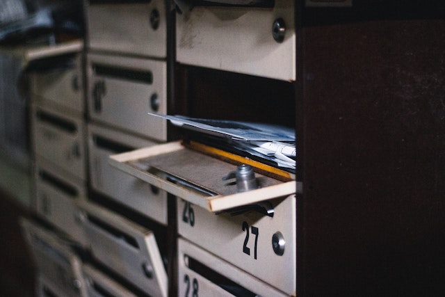 a stack of letters in an open community mailbox